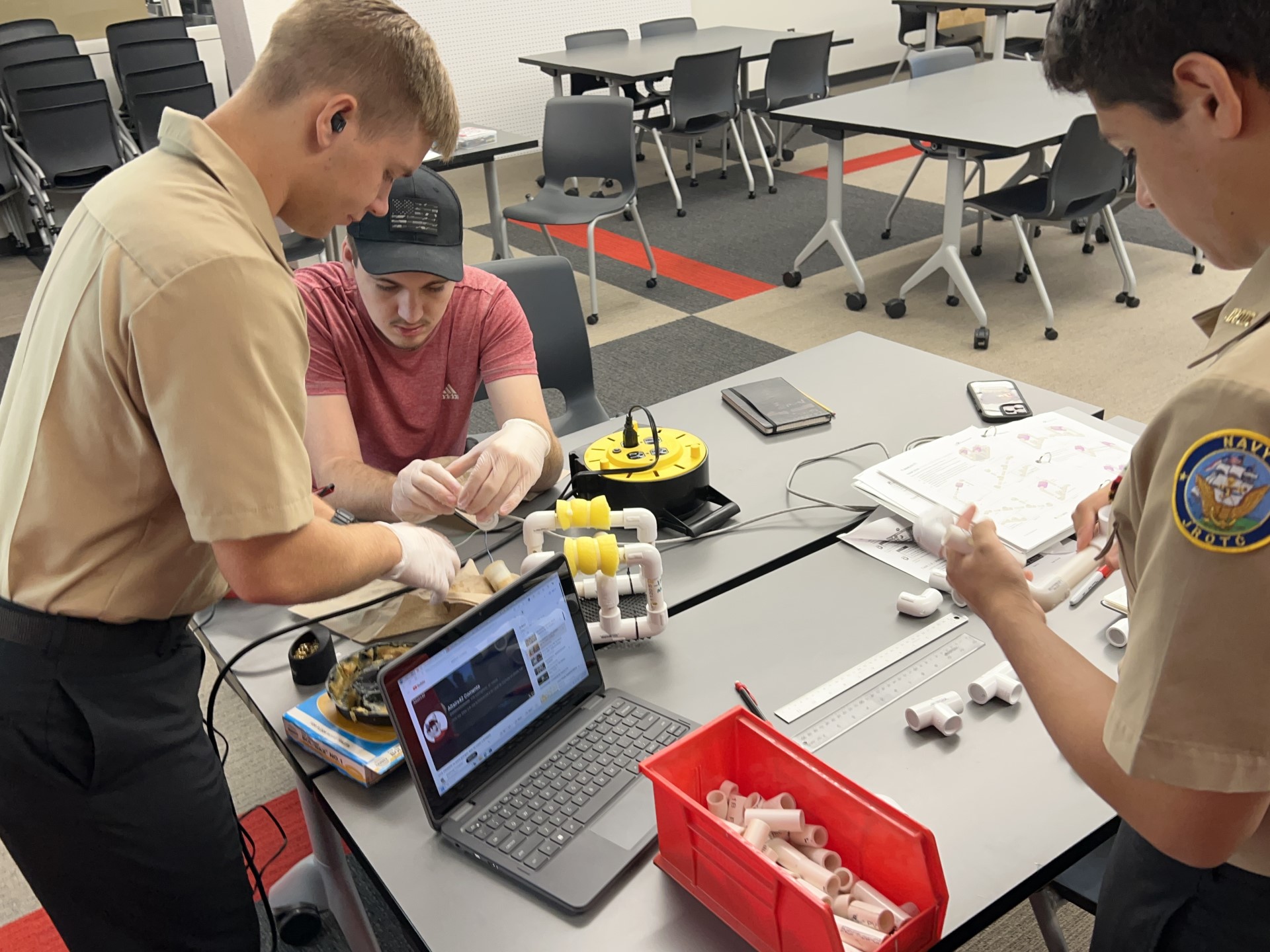 A group of people working on a computerDescription automatically generated